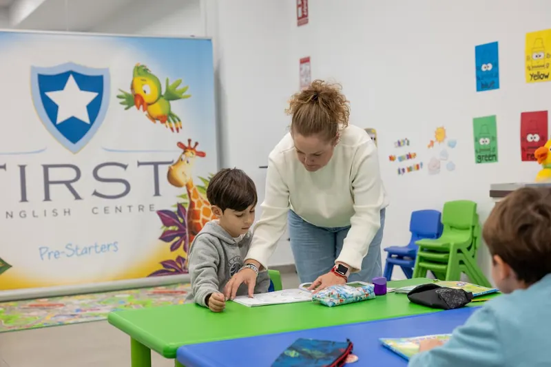 Profesora ayudando a un alumno en el aula de Pre-Starters.