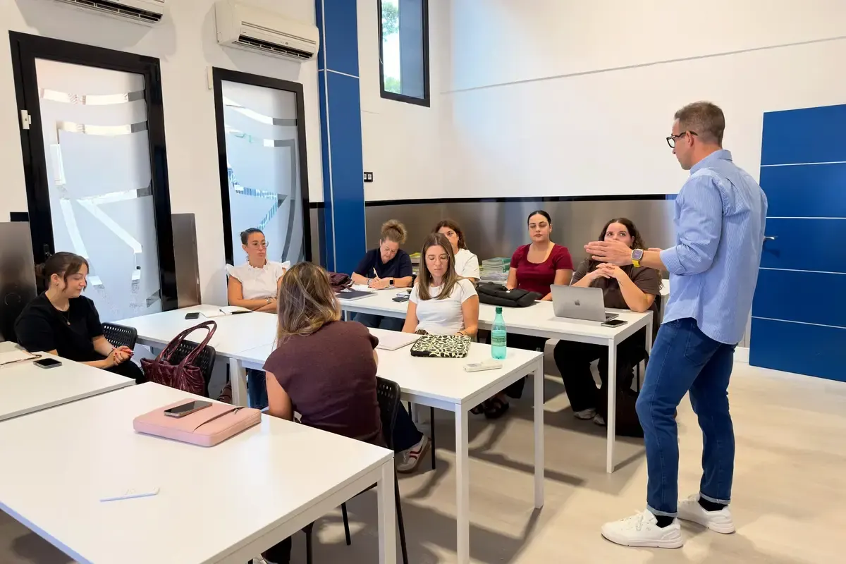 Reunión del profesorado: las profesoras escuchan a quien presenta de pie.